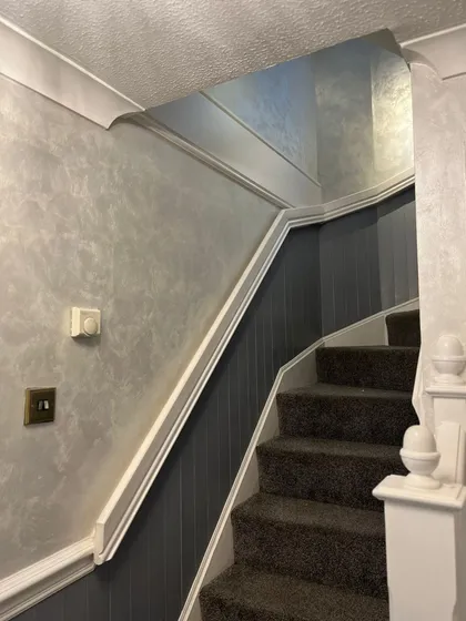 Staircase with wallpaper and panelling